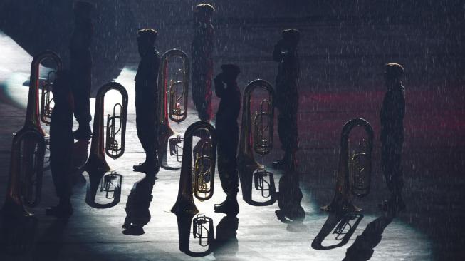 Anggota marching band dari Akademi Kepolisian dan Akademi Militer memberi hormat saat pengibaran bendera meski hujan turun deras pada Upacara Penutupan Asian Games ke-18 tahun 2018 di Stadion Utama GBK, Senayan, Jakarta, Minggu (2/9). ANTARA FOTO/INASGOC/Eka Nickmatulhuda