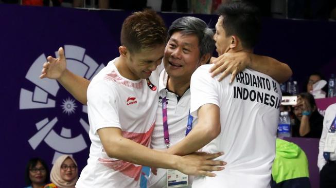 Pelatih ganda putra PBSI, Herry Iman Pierngadi (tengah), memeluk pasangan ganda putra Indonesia, Fajar Alfian/Muhammad Rian Ardianto. [Humas PBSI]