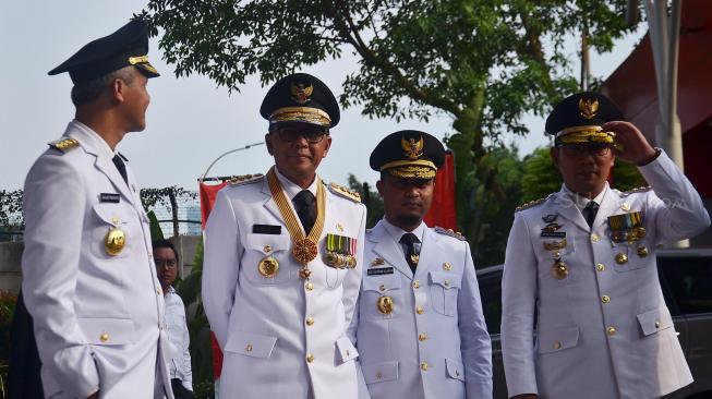 Menteri Dalam Negeri Tjahjo Kumolo beserta Gubernur Sulawesi Selatan Nurdin Abdullah, Wakil Gubernur Sulawesi Selatan Sudirman Sulaiman, Gubernur Jawa Barat Ridwan Kamil, Gubernur Jawa Tengah Ganjar Pranowo, Wakil Gubernur Jateng Taj Yasin Maimoen, Gubernur Bali I Wayan Koster, dan Wakil Gubernur Bali Tjokorda Oka Artha Ardhana Sukawati berjalan sebelum melakukan pertemuan dengan pimpinan KPK di Gedung KPK, Jakarta, Rabu (5/9). [Suara.com/Muhaimin A Untung]