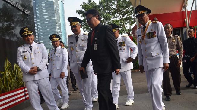 Menteri Dalam Negeri Tjahjo Kumolo beserta Gubernur Sulawesi Selatan Nurdin Abdullah, Wakil Gubernur Sulawesi Selatan Sudirman Sulaiman, Gubernur Jawa Barat Ridwan Kamil, Gubernur Jawa Tengah Ganjar Pranowo, Wakil Gubernur Jateng Taj Yasin Maimoen, Gubernur Bali I Wayan Koster, dan Wakil Gubernur Bali Tjokorda Oka Artha Ardhana Sukawati berjalan sebelum melakukan pertemuan dengan pimpinan KPK di Gedung KPK, Jakarta, Rabu (5/9). [Suara.com/Muhaimin A Untung]