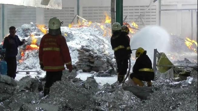 Petugas damkar memadamkan api di pabrik aluminium yang menyebabkan satu orang tewas dan tiga luka serius di Tangerang, Kamis (6/9/2018). (Anggy Muda/Suara.com)