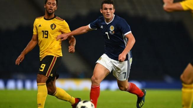 Gelandang Timnas Skotlandia, John McGinn (tengah), mengejar bola yang ditendang Moussa Dembele ke salah satu rekannya di Timnas Belgia dalam laga persahabatan di Hampden Park, Glasgow, Jumat (7/9/2018). [AFP/Andy Buchanan]