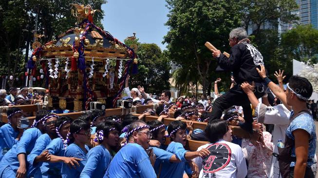 Sejumlah peserta mengangkat arak-arakan mikoshi saat Festival Budaya Pop Jak-Japan Matsuri 2018, di Gelora Bung Karno Senayan, Jakarta, Minggu (9/9). festival tersebut mengusung tema "Indonesia and Japan Always Together", dan dimeriahkan dengan parade mikoshi, cosplay japan, JKT 48 dan AKB 48. [Suara.com/Muhaimin A Untung]