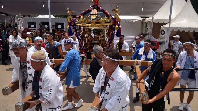Sejumlah peserta mengangkat arak-arakan mikoshi saat Festival Budaya Pop Jak-Japan Matsuri 2018, di Gelora Bung Karno Senayan, Jakarta, Minggu (9/9). festival tersebut mengusung tema "Indonesia and Japan Always Together", dan dimeriahkan dengan parade mikoshi, cosplay japan, JKT 48 dan AKB 48. [Suara.com/Muhaimin A Untung]