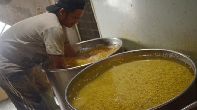 Pekerja melakukan proses pengolahan kacang kedelai di kawasan mampang prapatan, Jakarta, Minggu (9/9). [Suara.com/Muhaimin A Untung] 