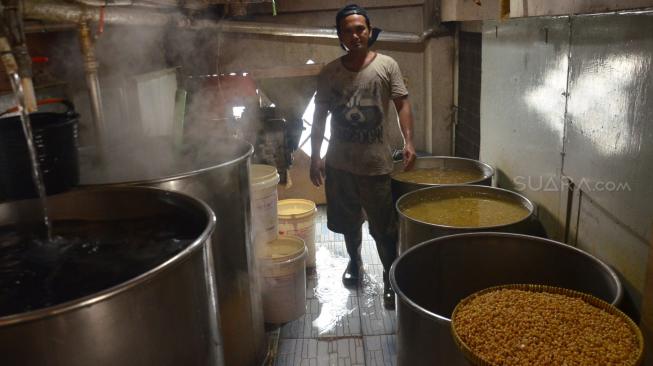 Pekerja melakukan proses pengolahan kacang kedelai di kawasan mampang prapatan, Jakarta, Minggu (9/9). [Suara.com/Muhaimin A Untung] 