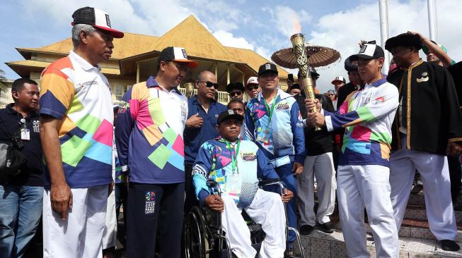 Menpora Imam Nahrawi (kedua kiri) didampingi Ketua Inapgoc Raja Sapta Oktohari (ketiga kanan) dan Wali Kota Ternate Burhan Abdurahman (kedua kiri) melakukan prosesi awal kirab obor (torch relay) Asian Para Games 2018 di Kedaton Kasultanan Ternate, Maluku Utara