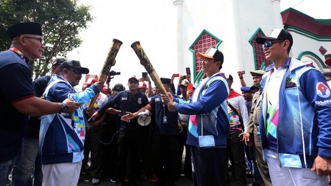 Menpora Imam Nahrawi (kedua kanan) didampingi Ketua Inapgoc Raja Sapta Oktohari (kanan) melakukan prosesi kirab obor (torch relay) Asian Para Games 2018 di Kedaton Kasultanan Ternate, Maluku Utara