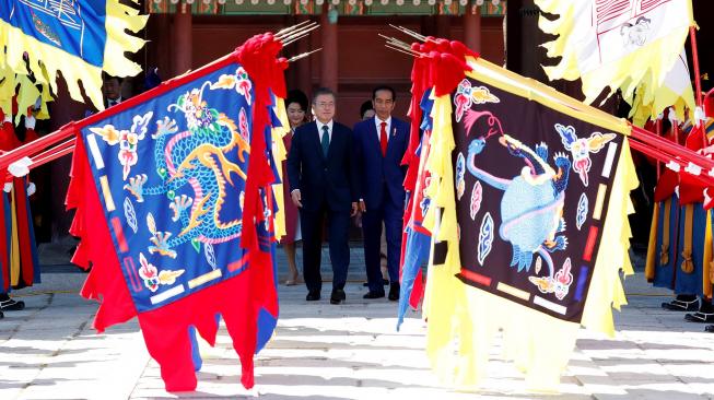 Presiden Korea Selatan Moon Jae-in (tengah kiri) dan Presiden Indonesia Joko Widodo (tengah kanan) menginspeksi penjaga kehormatan saat upacara penyambutan di istana Changdeokgung di Seoul, Korea Selatan