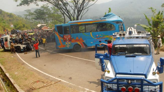 Petugas mengevakuasi mini bus berpenumpang puluhan wisatawan yang masuk jurang di Tanjakan Letter S, Kampung Bantarselang, Kecamatan Cikidang, Sukabumi, Jawa Barat