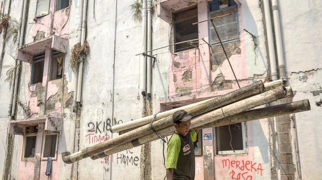 Pekerja mengangkat sisa bangunan saat pembongkaran Rumah Susun Karang Anyar,  Jakarta