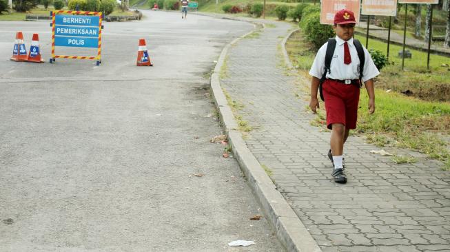 Siswa SD Nursaka (kiri), Warga Negara Indonesia yang bermukim di Tebedu, Sarawak, Malaysia berjalan kaki menuju Pos Lintas Batas Negara (PLBN) Entikong di Kabupaten Sanggau, Kalbar