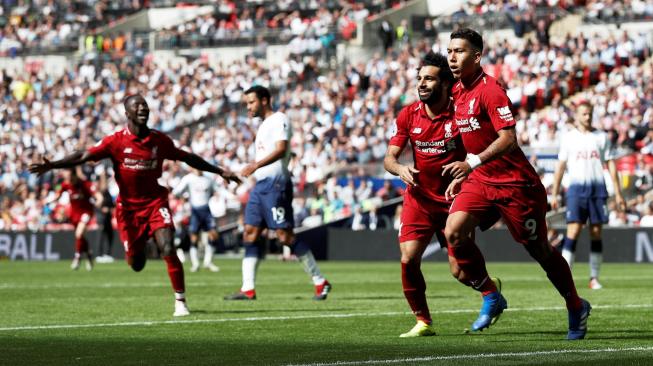 Pemain Liverpool, Roberto Firmino dan Mohamed Salah, saat merayakan gol kedua timnya ke gawang Tottenham Hotspur, dalam laga lanjutan Liga Inggris di Stadion Wembley, London, Sabtu (15/9/2018). [Adrian DENNIS / AFP]