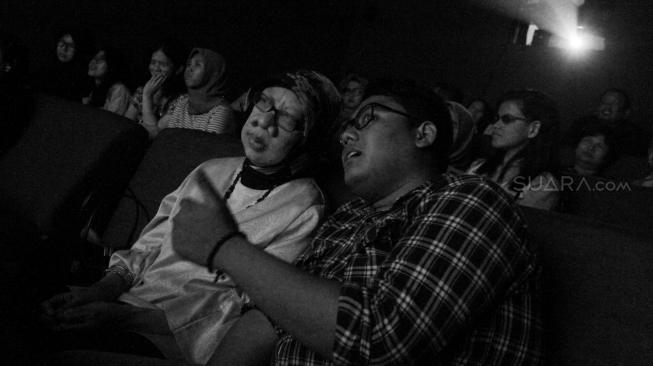 Penyandang tunanetra didampingi relawan saat menonton film dokumenter di sebuah bioskop di Paviliun 88, Petogogan, Jakarta Selatan, Sabtu (15/9). [Suara.com/Oke Dwi Atmaja]