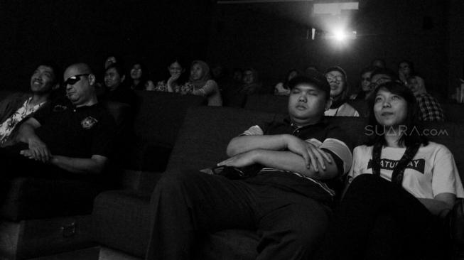 Penyandang tunanetra didampingi relawan saat menonton film dokumenter di sebuah bioskop di Paviliun 88, Petogogan, Jakarta Selatan, Sabtu (15/9). [Suara.com/Oke Dwi Atmaja]