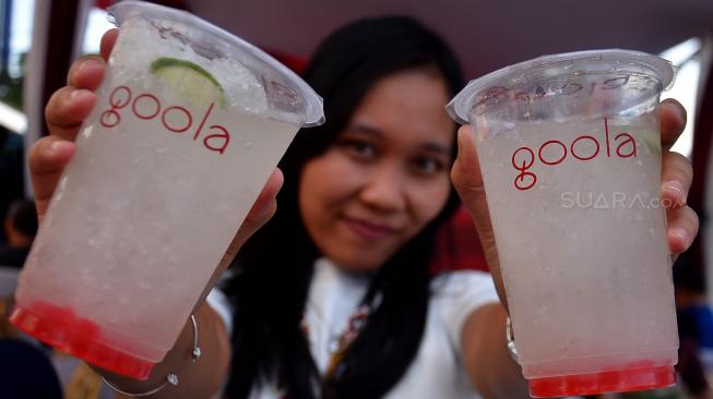 Warga memperlihatkan minuman Goola saat grand opening Goola di Markobar, Cikini, Jakarta, Minggu (16/9). [Suara.com/Muhaimin A Untung]