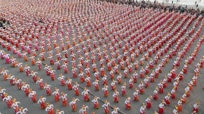 Penari mementaskan Tari Tenun saat upaya pencatatan rekor Museum Rekor Dunia Indonesia (MURI) dalam rangkaian kegiatan Petitenget Festival 2018 di kawasan Pantai Petitenget, Badung, Bali, Minggu (16/9). [ANTARA FOTO/Fikri Yusuf]