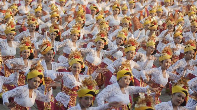 Penari mementaskan Tari Tenun saat upaya pencatatan rekor Museum Rekor Dunia Indonesia (MURI) dalam rangkaian kegiatan Petitenget Festival 2018 di kawasan Pantai Petitenget, Badung, Bali, Minggu (16/9). [ANTARA FOTO/Fikri Yusuf]