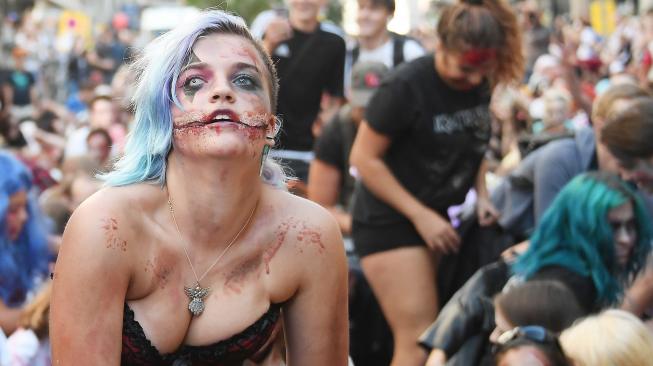 Warga memakai kostum dan berdandan menyerupai zombie saat acara Zombie Walk di kota Strasbourg, Prancis, Sabtu (15/9/2018). [AFP/FREDERICK]