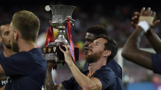 Kapten Barcelona Lionel Messi mengangkat piala Super Spanyol usai timnya mengalahkan Sevilla 2-1, 12 Agustus 2018 [AFP]