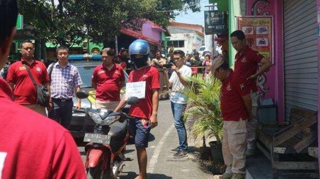 Tersangka (bertutup helm) memperagakan adegan pembunuhan pemandu karaoke di kompleks Sunan Kuning, Kota Semarang, Selasa (18/9 - 2018). [Semarangpos.com/Imam Yuda S]