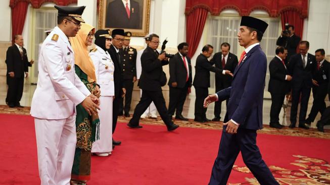 Presiden Joko Widodo (kanan) memberi ucapan selamat kepada Gubernur Nusa Tenggara Barat (NTB) Zulkifliemansyah (kiri) dan Wakil Gubernur Sitti Rohmi Djalilah (ketiga kiri) seusai pelantikan di Istana Negara Jakarta, Rabu (19/9). ANTARA FOTO/Wahyu Putro