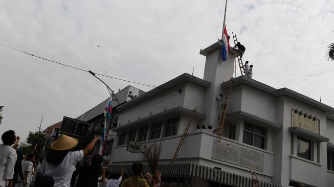 Warga menyaksikan perobekan bendera Belanda yang berkibar di Hotel Majapahit saat teatrikal peristiwa perobekan bendera di Hotel Yamato sekarang Hotel Majapahit di Jalan Tunjungan, Surabaya, Jawa Timur, Rabu (19/9). ANTARA FOTO/Zabur Karuru