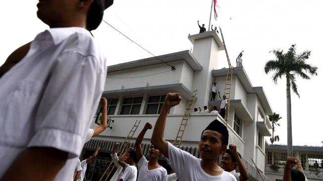 Warga bersorak ketika bendera Merah Putih berkibar di Hotel Majapahit saat teatrikal peristiwa perobekan bendera di Hotel Yamato sekarang Hotel Majapahit di Jalan Tunjungan, Surabaya, Jawa Timur, Rabu (19/9). ANTARA FOTO/Zabur Karuru