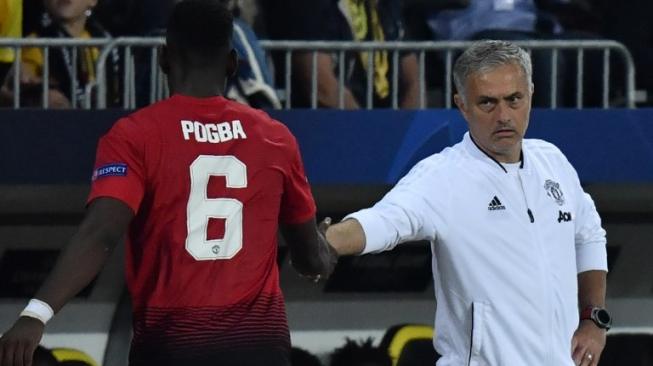 Manajer Manchester United, Jose Mourinho (kanan) berjabat tangan dengan gelandang Paul Pogba pada laga kontra Young Boys. [Alain GROSCLAUDE / AFP]