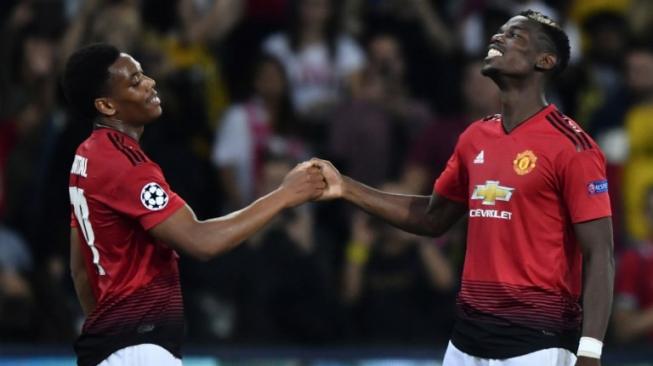 Gelandang Manchester United, Paul Pogba (kanan), merayakan gol ke gawang Young Boys bersama penyerang Anthony Martial. [Fabrice COFFRINI / AFP]