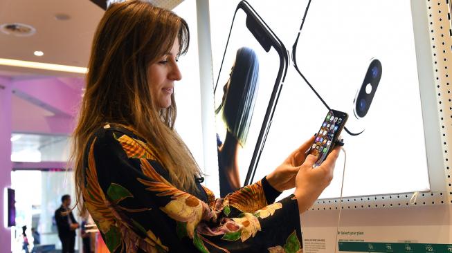 Seorang wanita memeriksa rangkaian iPhone XS terbaru di toko di Melbourne, Australia, Jumat ( 21/9). [AFP/William West]