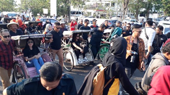 Dewi Perssik dan Zaskia Gotik saat diarak naik becak untuk menghadiri Gala Premiere film Arwah di Karawang, Jawa Barat, Sabtu (22/9/2018) [Suara.com/Ismail]