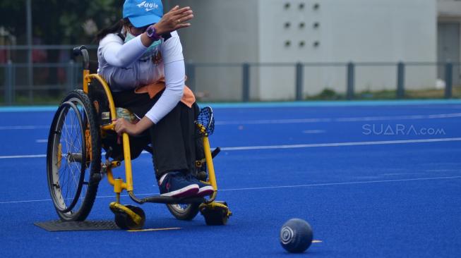 Atlet Para Games Indonesia cabang olahraga Lawn Bowls berlatih di Lapangan Hoki Kompleks GBK, Jakarta, Sabtu (22/9). [Suara.com/Muhaimin A Untung] 