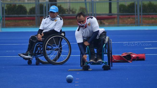 Atlet Para Games Indonesia cabang olahraga Lawn Bowls berlatih di Lapangan Hoki Kompleks GBK, Jakarta, Sabtu (22/9). [Suara.com/Muhaimin A Untung] 