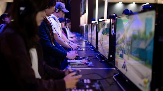 Seorang pengunjung memainkan video game di Tokyo Game Show, Tokyo, Jepang, Jumat (21/9). [AFP/ Martin BUREAU]