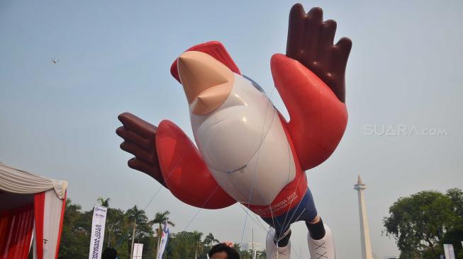 Peserta membawa balon maskot Momo saat Parade Momo di kawasan Monas, Jakarta, Minggu (23/9). [Suara.com/Muhaimin A Untung]