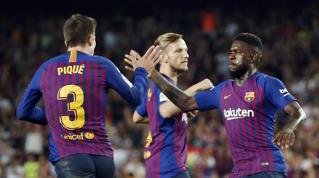 Bek Barcelona Samuel Umtiti memberi selamat kepada bek Barcelona  Gerard Pique untuk golnya selama pertandingan Barcelona melawan Girona di stadion Camp Nou, Barcelona, Spanyol,Minggu (23/9). [AFP/Pau Barrena] 