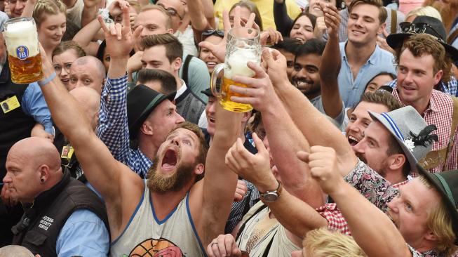 Para peserta mengangkat gelas bir saat pembukaan festival bir terbesar di dunia Oktoberfest ke-185 di Munich, Jerman, Sabtu (22/9). [AFP/Christof STACHE]