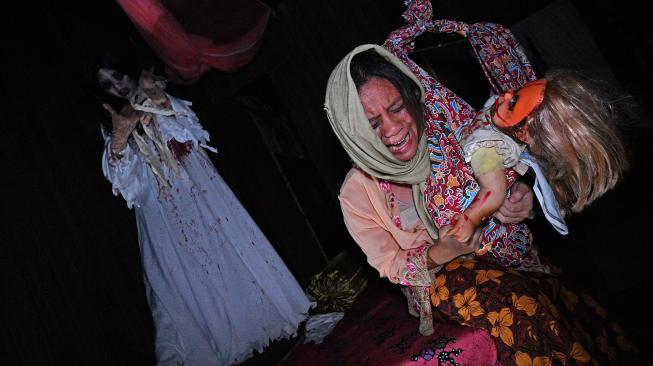 Seorang aktor menggunakan kostum menyeramkan saat preview media 'Halloween Horror Nights' di Universal Studio,Singapura, Minggu (24/9).  [AFP/Roslan RAHMAN]