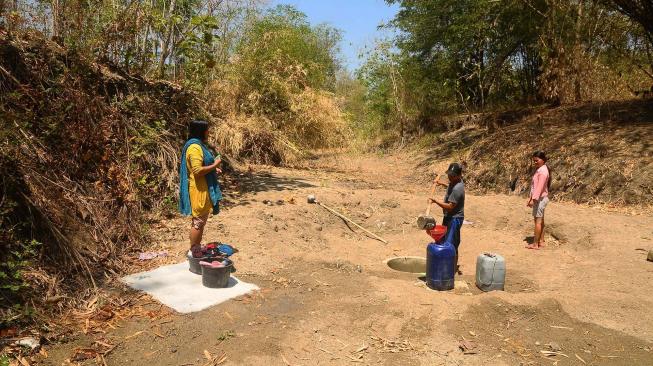 Warga mengambil air dari sumur buatan yang digali di dasar sungai di Desa Ketro, Grobogan, Jawa Tengah, Selasa (25/9). [ANTARA FOTO/Yusuf Nugroho]