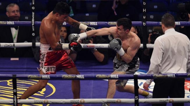 Petinju Inggris, Anthony Crolla (tengah), melontarkan hook kanan ke dagu lawannya Edson Ramirez (Meksiko) dalam duel yang berlangsung di The Principality Stadium, Cardiff, Wales, 31 Maret 2018. [AFP/Oli Scarff]