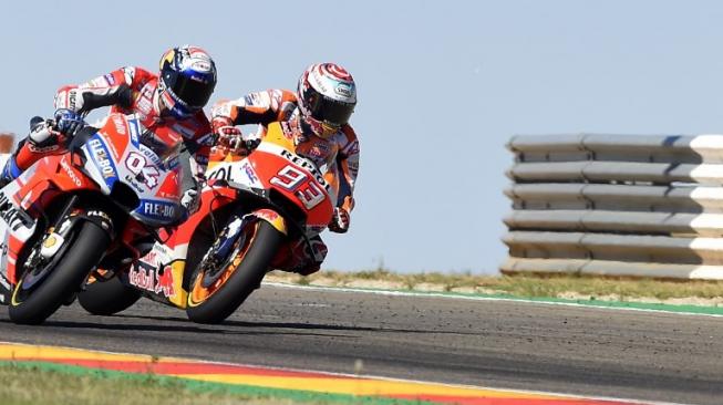 Pebalap Repsol Honda, Marc Marquez (kanan) dan bersaing ketat dengan rivalnya dari Ducati, Andrea Dovizioso, pada balapan MotoGP Aragon, Minggu (23/9/2018). [AFP/Jose Jordan]