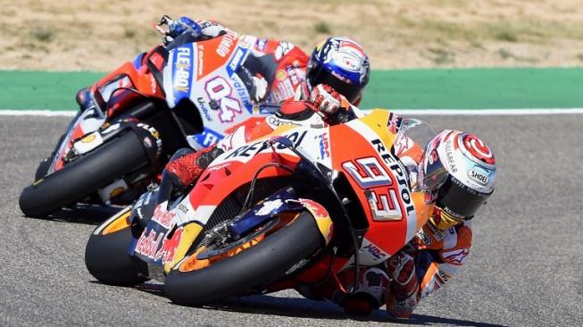 Pebalap Repsol Honda, Marc Marquez (depan) dan bersaing ketat dengan rivalnya dari Ducati, Andrea Dovizioso, pada balapan MotoGP Aragon, Minggu (23/9/2018). [AFP/Jose Jordan]