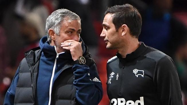 Manajer Manchester United Jose Mourinho (kiri) berbicara dengan manajer Derby County Frank Lampard saat turun minum pada laga Piala Liga Inggris di Old Trafford. Paul ELLIS / AFP