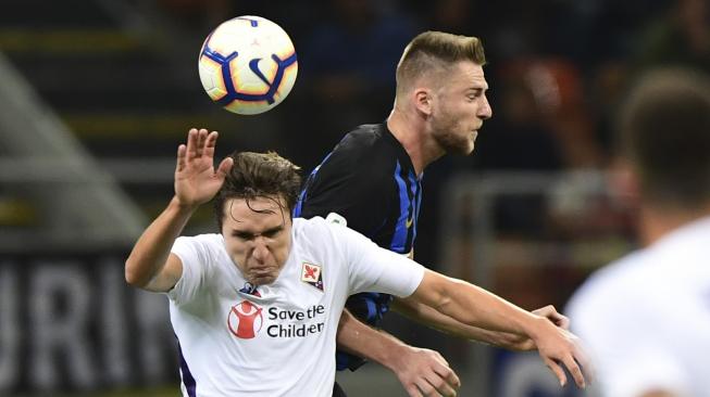 Pemain depan Fiorentina, Federico Chiesa berusaha merebut bola dari bek Inter Milan, Milan Skriniar selama pertandingan  Inter Milan melawan Fiorentina di Stadion San Siro, Milan, Italia, Selasa (25/9). [AFP/Miguel MEDINA]
