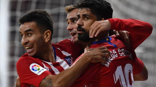 Pemain Atletico Madrid Antoine Griezmann (tengah) merayakan golnya ke gawang Huesca dengan Angel Correa (kiri) dan Diego Costa di lanjutan Liga Spanyol. GABRIEL BOUYS / AFP