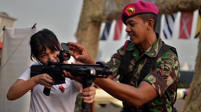 Warga menjajal senapan saat pameran Alat Utama Sistem Persenjataan (Alutista) di Monumen Nasional, Jakarta, Kamis (27/9). [Suara.com/Muhaimin A Untung]