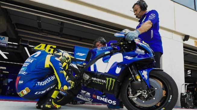 Pebalap Yamaha, Valentino Rossi (kiri), tengah berdoa sebelum menjalani latihan bebas kedua MotoGP Aragon, Jumat (21/9/2018). [AFP/Jose Jordan]