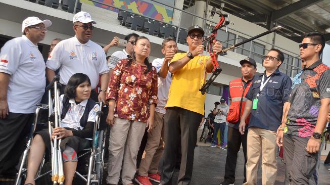 Menteri Sosial Agus Gumiwang mencoba panahan saat meninjau venue Istora dan Panahan Asian Para Games di kawasan GBK,  Jakarta,  Jumat (28/9). [Suara.com/Muhaimin A Untung]  