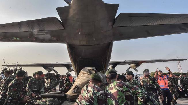 Prajurit TNI memasukan logistik kedalam pesawat untuk tugas misi kemanusian gempa Palu, Sulawesi Tengah di Base Ops Pangkalan Udara Militer Halim Perdana Kusuma, Jakarta, Sabtu (29/9). ANTARA FOTO/Muhammad Adimaja